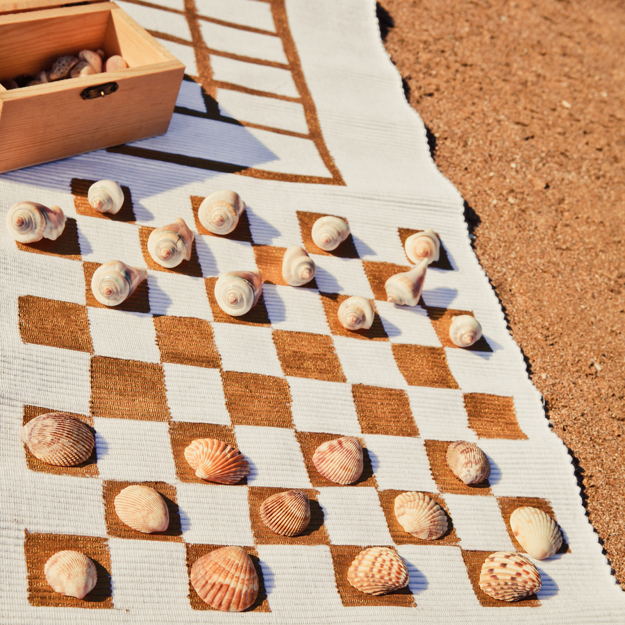 Outdoor game mat to take with you to the beach or park- this DIY outdoor classic game board is the perfect way to put your shell collection to good use