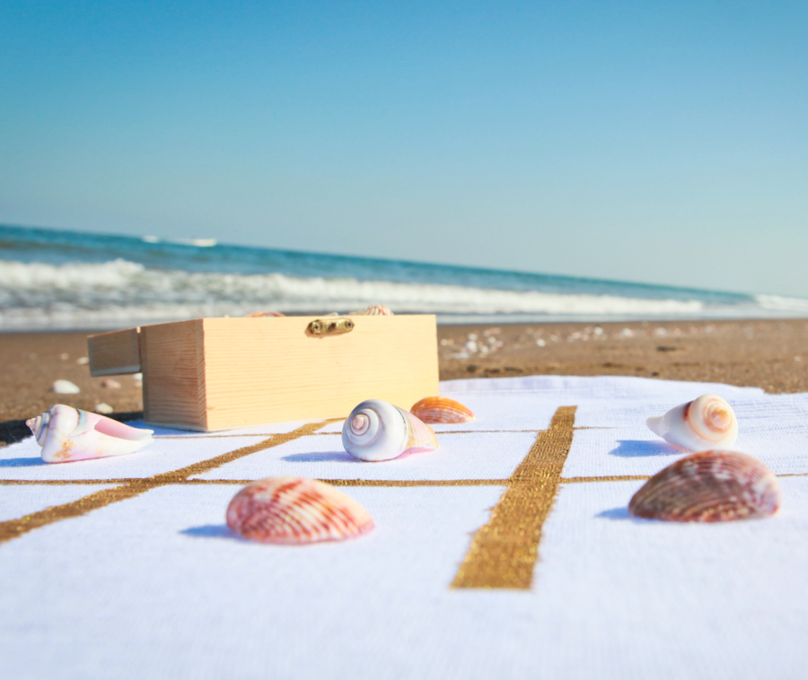 Outdoor game mat to take with you to the beach or park- this DIY outdoor classic game board is the perfect way to put your shell collection to good use