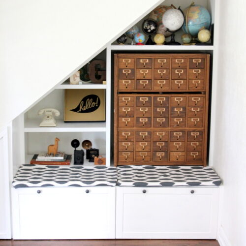 The perfect use for the space under the stairs- book shelves, a bench, drawers and even a little closet